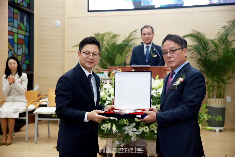 교회를 대표해서 신성열 장로가 담임 목사에게 취임패 증정 중